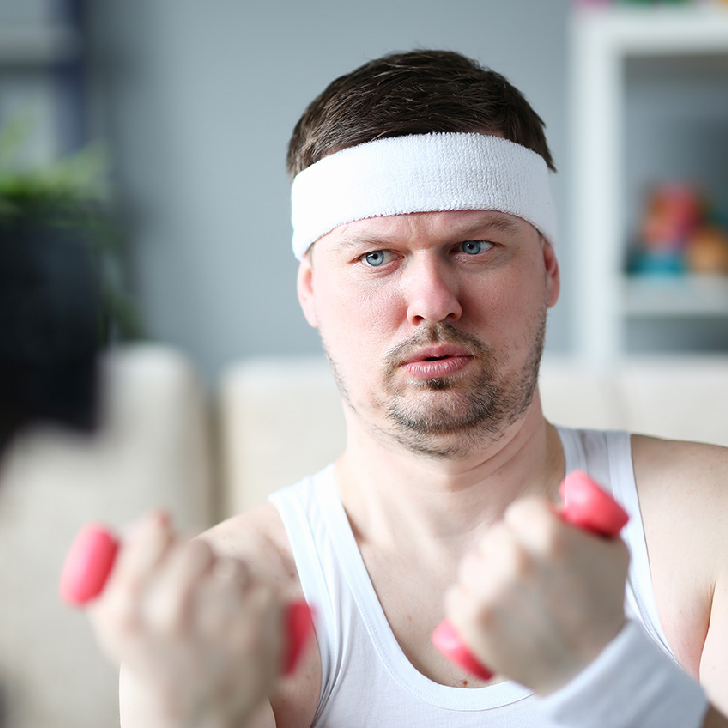 Harry Smith wearing a headband and lifting comically small, pink weights